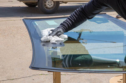 Person polishing a replacement windshield in Norwalk, CT.