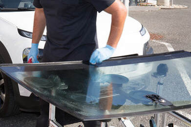 Person prepping a new windshield for installation in Norwalk.